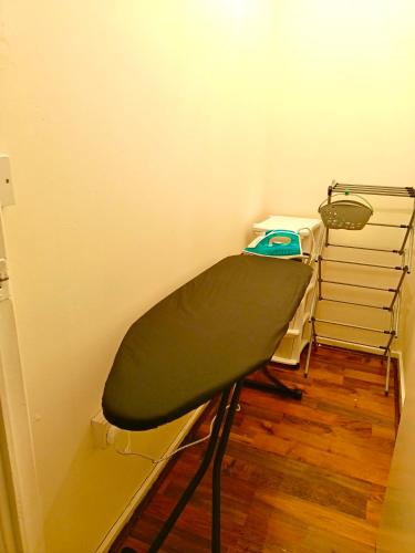 a green bar stool in a corner of a room at Heart of Telford Stylish 2-Bedroom in Telford
