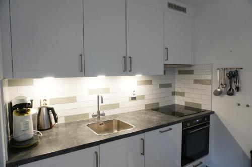 a kitchen with white cabinets and a sink at Kustverhuur, Park Schoneveld, Zeemeeuw 138 in Breskens