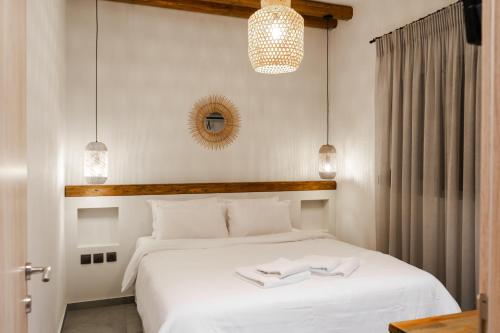 una camera da letto con un letto con due asciugamani bianchi di Aellw cozy apartment 2 a Néa Thésis
