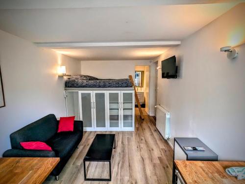 un salon avec un canapé et un lit dans l'établissement Ma Cabane Jardin en Ville, à Rennes