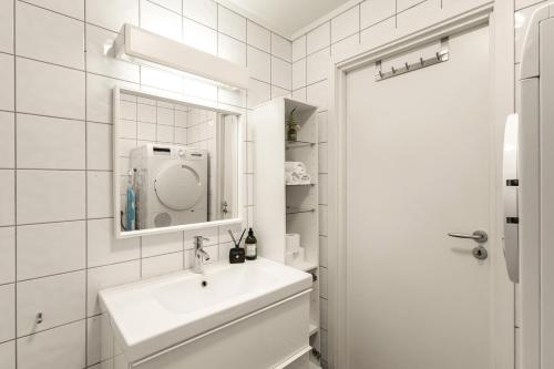 a white bathroom with a sink and a mirror at Family Friendly - Modern - City Central in Bergen