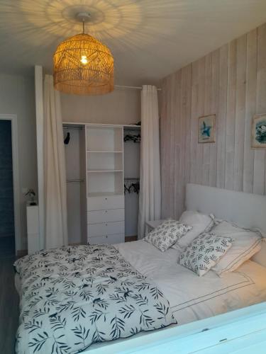 une chambre avec un lit et un lustre dans l'établissement La Maison du Clocher, à Rivedoux-Plage
