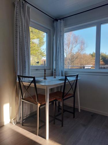 a dining room table with two chairs and a window at Charming house in the nature in Kärna