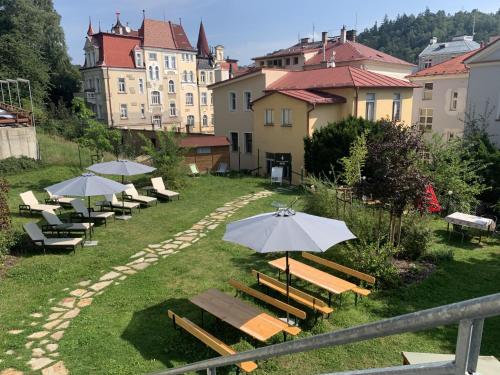 a row of benches with umbrellas in the grass at Spa Hotel Devin in Mariánské Lázně