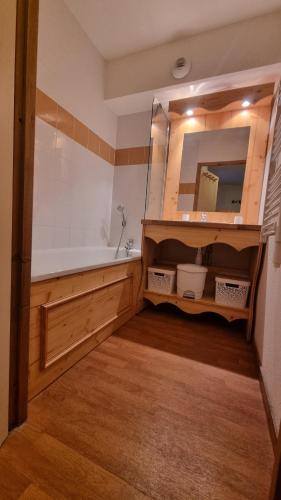 une salle de bain avec une baignoire et un miroir dans l'établissement Le Hameau SPA & PISCINE appartement 2 pieces 6pers by Alpvision Residences, à Orelle