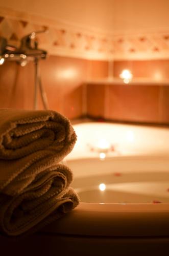 a bathroom with a tub and a sink with a towel at Dolce Vita Suites Boutique in Prague