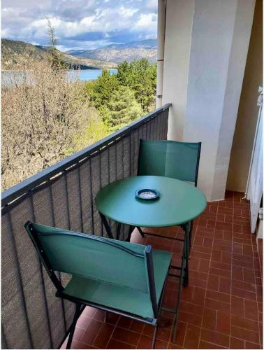une table et des chaises sur un balcon avec vue dans l'établissement Les balcons du Lac - Studio Belle Vue, aux Salles-sur-Verdon