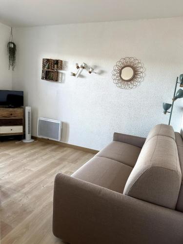 un salon avec un canapé et une télévision dans l'établissement Les balcons du Lac - Studio Belle Vue, aux Salles-sur-Verdon