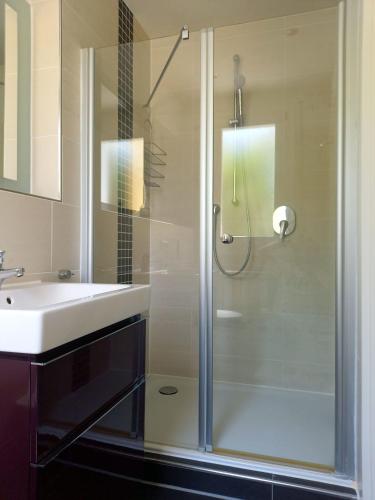 a bathroom with a glass shower and a sink at Maria in Caleri