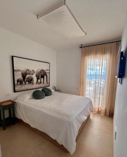 a bedroom with a bed with a picture of elephants at Beach House Brotonss in El Campello
