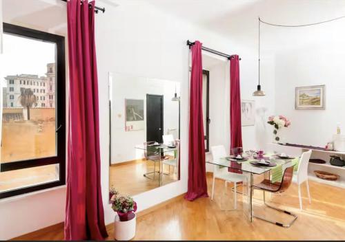 a dining room with red curtains and a table at LoL-ApartmenT, in the heart of Trastevere in Rome