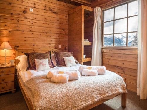 une chambre avec un lit dans un mur en bois dans l'établissement Chalet Noëlla - Chalet traditionnel en bois à 250m des pistes, centre et animations, 14 pers - FR-1-513-60, à La Tania