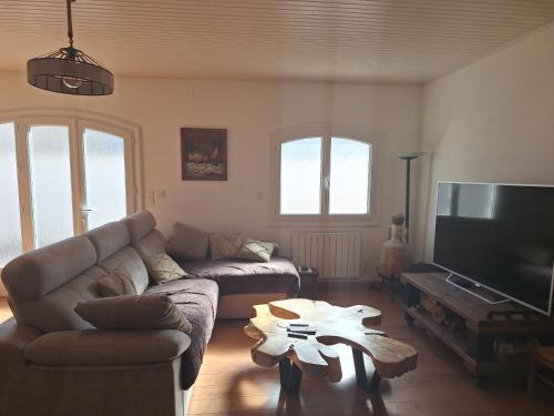 un salon avec un canapé et une table dans l'établissement maison en bord de mer, à Port-de-Bouc