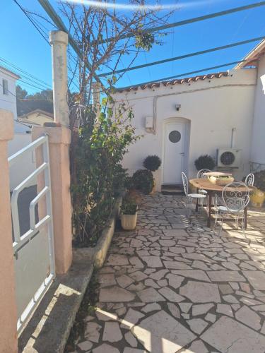 d'une terrasse avec une table et une clôture. dans l'établissement maison en bord de mer, à Port-de-Bouc