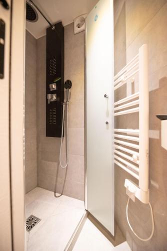 une douche avec une porte vitrée dans une salle de bain dans l'établissement CIA - Studio Pierre Fontaine, à Paris