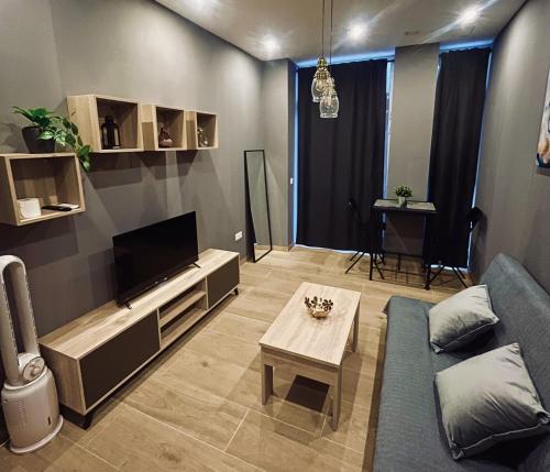 a living room with a blue couch and a tv at CITY FLATS - Avenida Baleares in Valencia