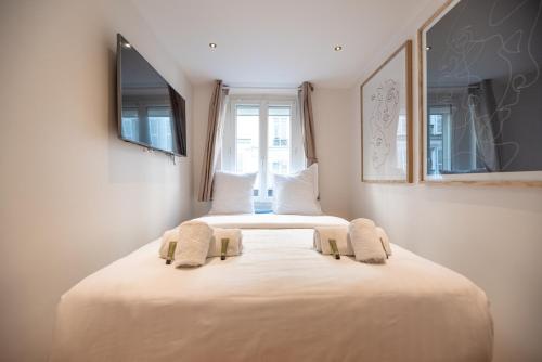 une chambre avec deux lits avec des serviettes dessus dans l'établissement CIA - Studio Pierre Fontaine, à Paris