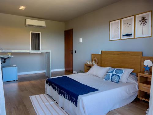 a bedroom with a large bed with blue pillows at Villa Mar - Baia Formosa in Baía Formosa