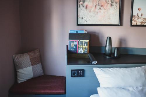 a room with a bed with a chair and a phone at The Circus Hotel in Berlin