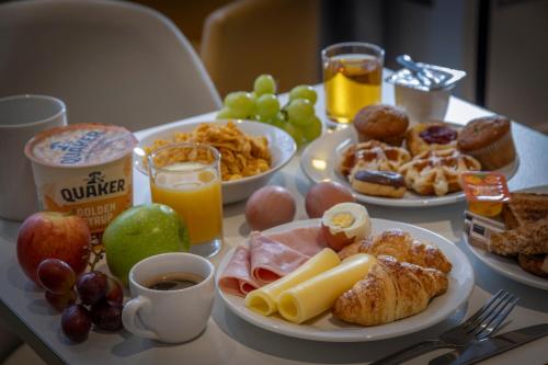 a table topped with plates of breakfast foods and drinks at Best Western Kensington Olympia Hotel in London