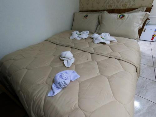 un lit avec des couches et des serviettes dessus dans l'établissement Pousada São Judas Tadeu, à Cachoeira Paulista