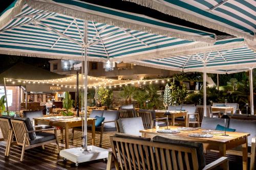a restaurant with tables and chairs and umbrellas at Grande Real Santa Eulalia Resort & Hotel Spa in Albufeira