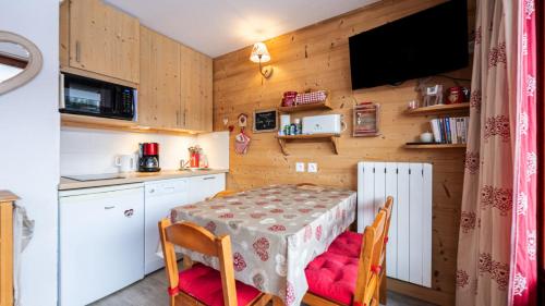 une cuisine avec une table et des chaises et une cuisine avec une télévision dans l'établissement Les Eterlous N35 - 2P4, à Morillon