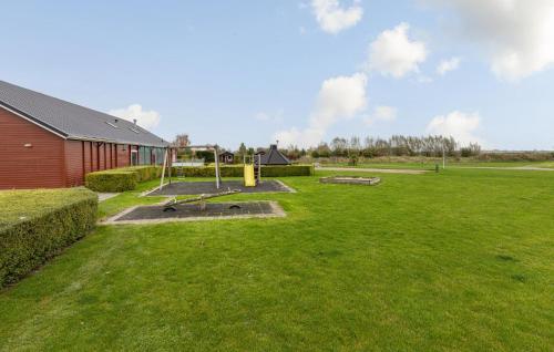 a grassy yard with a playground in front of a building at 2 Bedroom Cozy Home In Wagenborgen in Wagenborgen