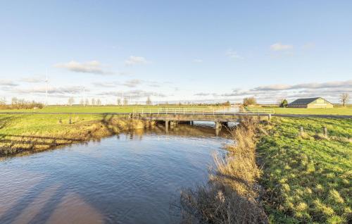 a bridge over a river in a field at 2 Bedroom Cozy Home In Wagenborgen in Wagenborgen
