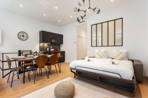 une chambre avec un lit, une table et des chaises dans l'établissement CIA - Port de Bastille, à Paris
