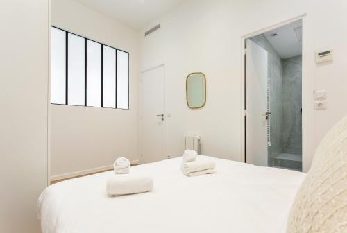 - une chambre blanche avec 2 serviettes sur un lit dans l'établissement CIA - Port de Bastille, à Paris