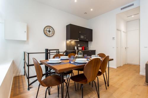 une cuisine et une salle à manger avec une table et des chaises en bois dans l'établissement CIA - Port de Bastille, à Paris
