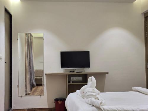 a hotel room with a tv and a bed at Hotel Vilaasitaa inn Ujjain in Ujjain