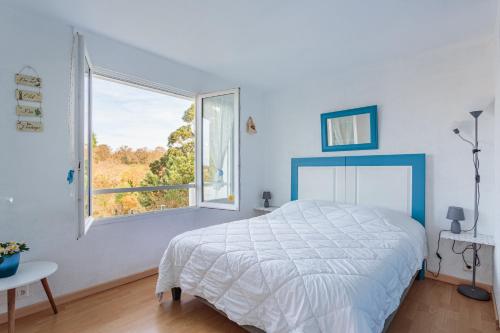 une chambre avec un lit et une grande fenêtre dans l'établissement Artzain appartement au calme à mi chemin entre la mer et la campagne, à Urrugne