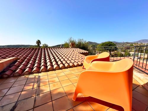 two orange chairs sitting on a tile roof at Patio on the Simius beach in Simius