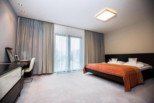 a bedroom with a bed and a large window at Hotel Magnus Trenčín in Trenčín