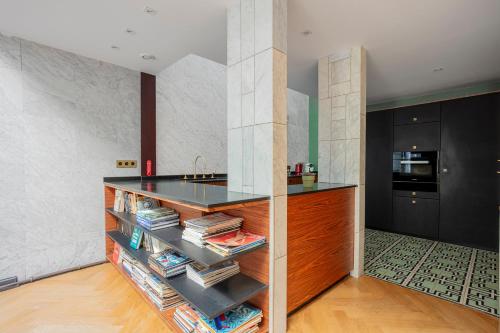 - une cuisine avec un comptoir et des livres dans l'établissement Parisian loft with plenty of light and solarium in Bastille area, à Paris