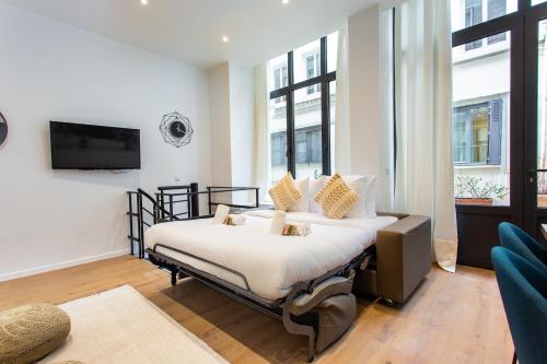 une chambre avec un lit, une télévision et des fenêtres dans l'établissement CIA - Bassins de Bastille, à Paris