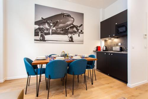 une cuisine et une salle à manger avec une table et des chaises bleues dans l'établissement CIA - Bassins de Bastille, à Paris