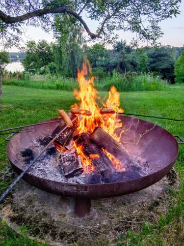 a fire in a grill in a field at Dom wakacyjny nad jeziorem Zajączkowskim in Pniewy