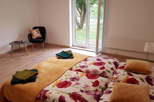 a bedroom with two beds and a chair and a window at Dom wakacyjny nad jeziorem Zajączkowskim in Pniewy
