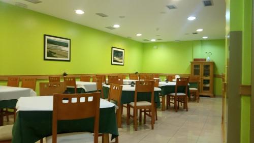 une salle à manger avec des murs verts, des tables et des chaises dans l'établissement Hotel Ancora da Ria 1* Superior, à Porto do Son