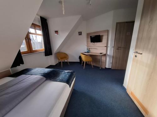 a bedroom with a bed and a desk and a television at HOTEL BIKE & HIKE in Obersuhl