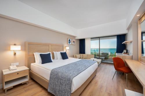 a hotel room with a large bed and a desk at Sural Saray Hotel in Side