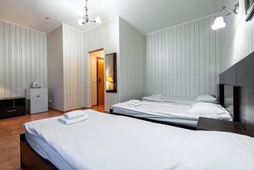 a bedroom with two beds and a hallway with a door at Hotel Verhovina in Kyiv