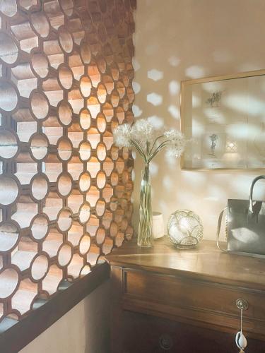 un mur en bois avec un vase de fleurs sur une table dans l'établissement Chez Sophie, à Rosières