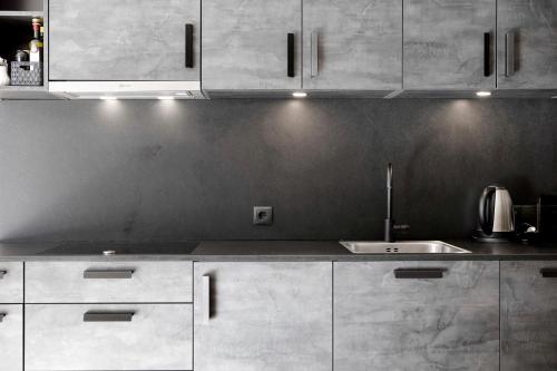 a kitchen with white cabinets and a sink at Chalet-Suite Wald in Selva dei Molini