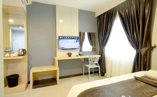 a bedroom with a bed and a desk with a computer at Hotel Holitel in Parit