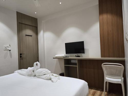 a hotel room with a towel animal laying on a bed at Hotel Vilaasitaa inn Ujjain in Ujjain