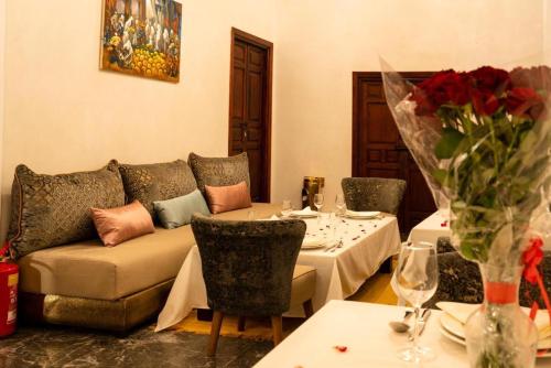 a living room with a couch and a table with tables and chairs at Palais Aix Kabaj &Spa in Marrakech